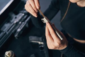 handgun cleaning in Sarasota | Gun owner performing handgun cleaning on a workbench using a firearm maintenance kit