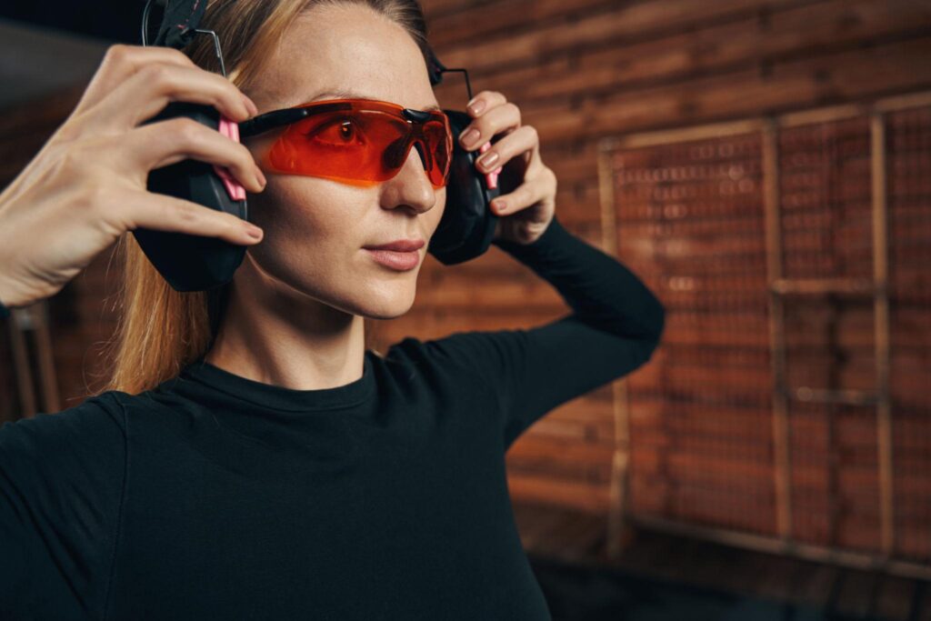 First-time indoor shooting range visitor wearing protective safety glasses and hearing protection